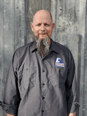 A man with a beard and mustache wearing an industrial shirt.