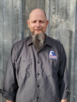 A man with a beard and mustache wearing an industrial shirt.