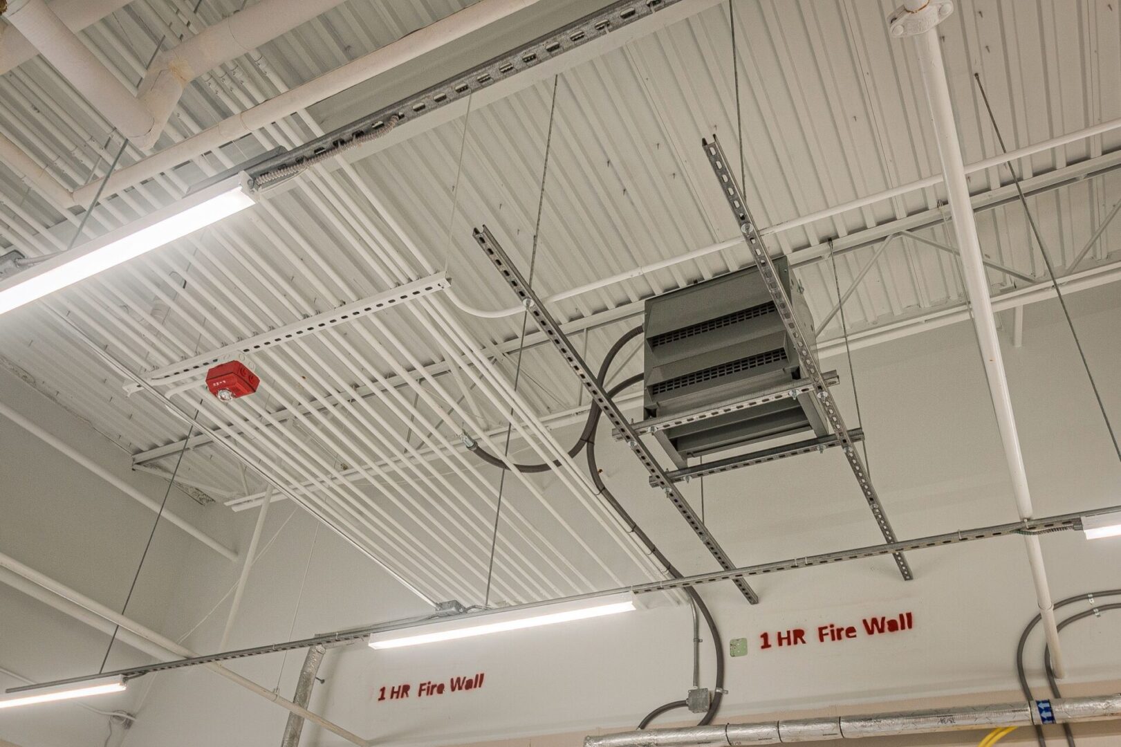 A fire exit with ladders and wires hanging from the ceiling.