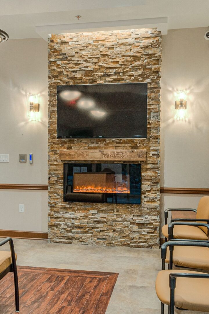 A stone fireplace with a television mounted above it.