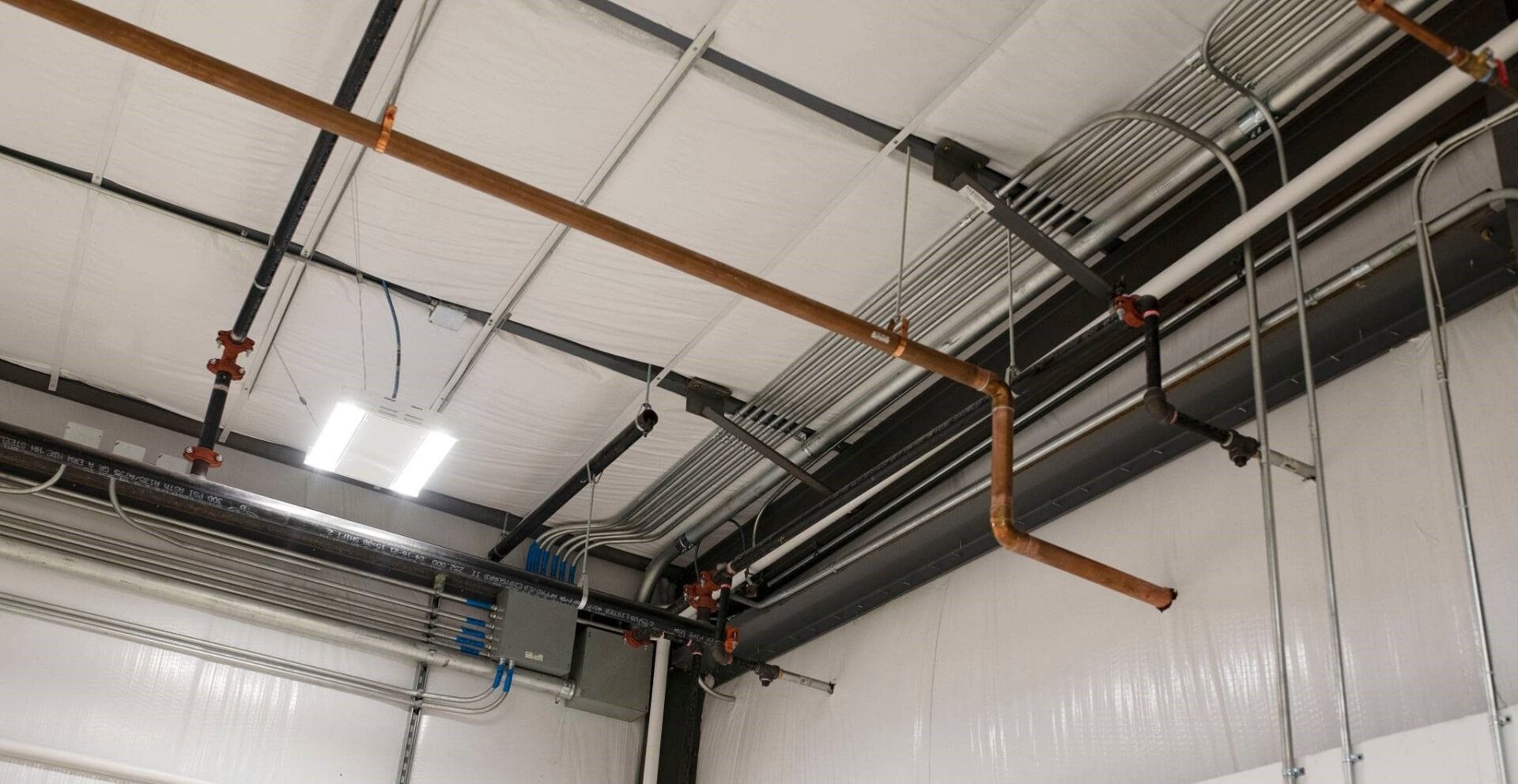 A view of pipes and wires in an industrial building.