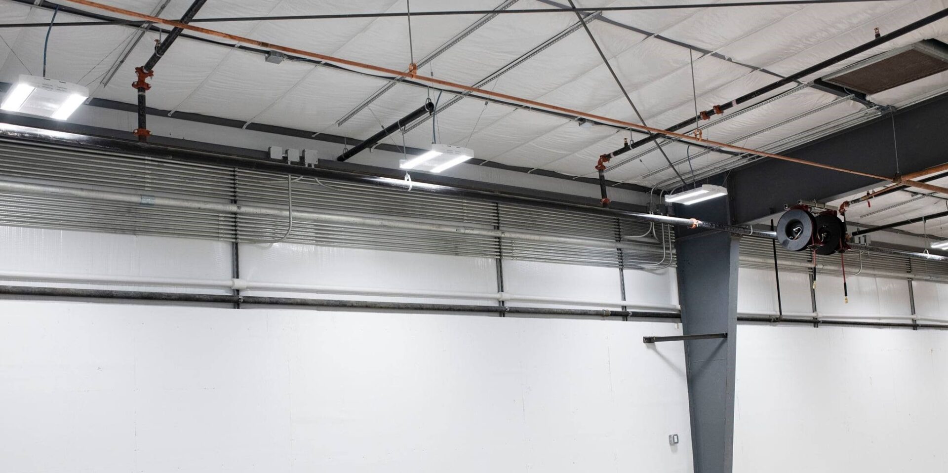 A garage with two lights and a ceiling fan.