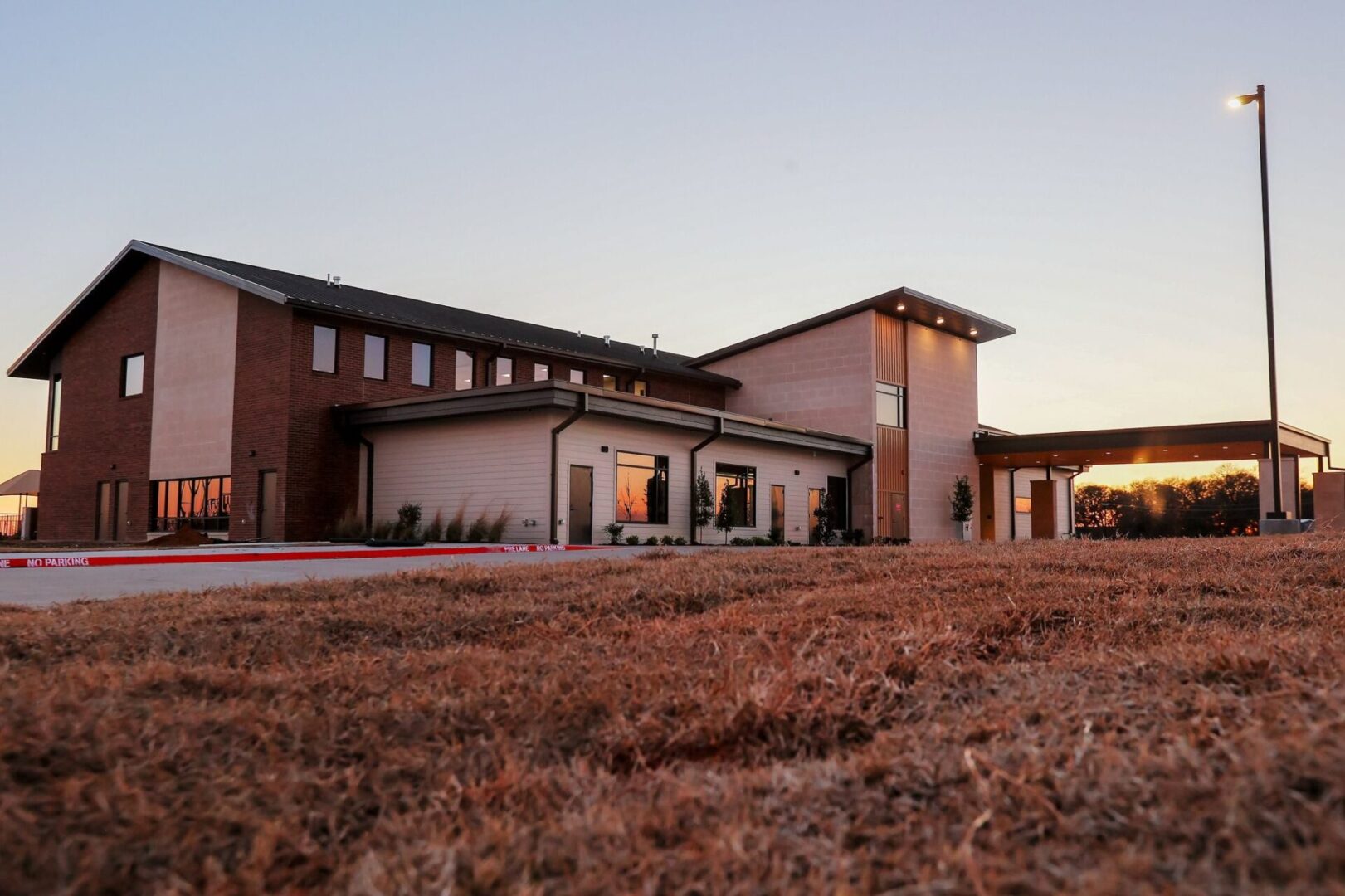 A large building with a long driveway in the foreground.